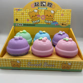 Set of colorful bell-shaped toys with a 'Sweet Bear' branded box on a gray background